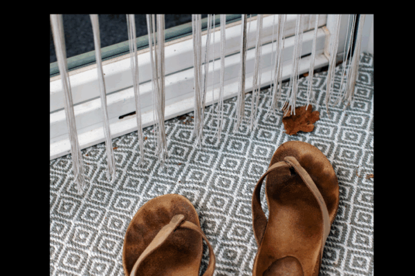 A pair of worn sandals at a doorstep